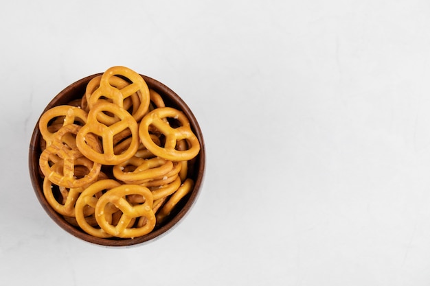 Bretzels crackers with salt in wooden bowl isolated on a white surface 