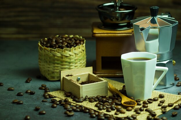 Brew black coffee in white cup and morning lighting. Roasted coffee beans in bamboo basket.