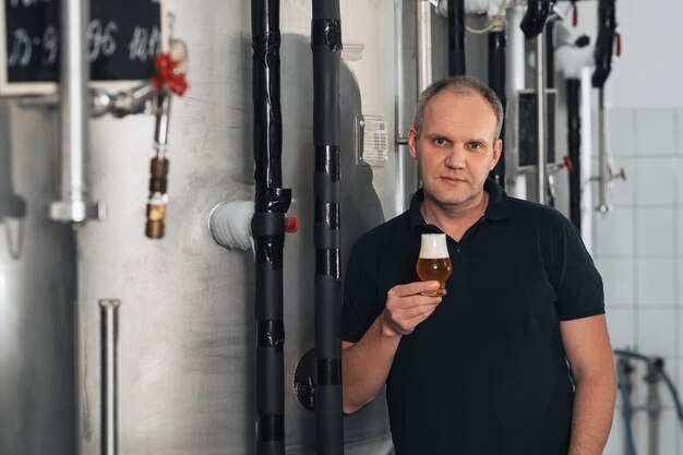 Brewer at a brewery with glass of fresh beer