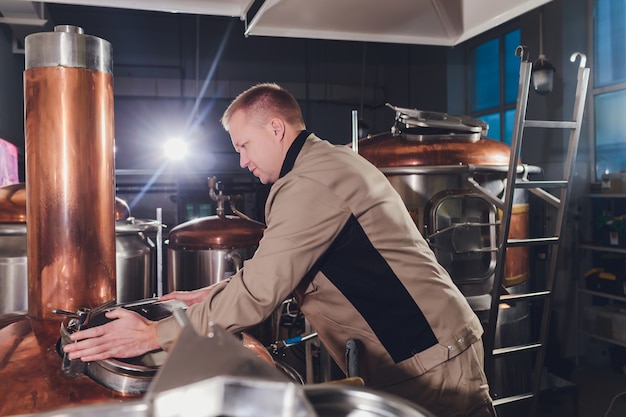 Brewer in brewhouse pouring out the malt to the tank.