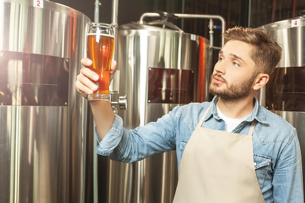 Brewer checking quality of the freshly tapped beer