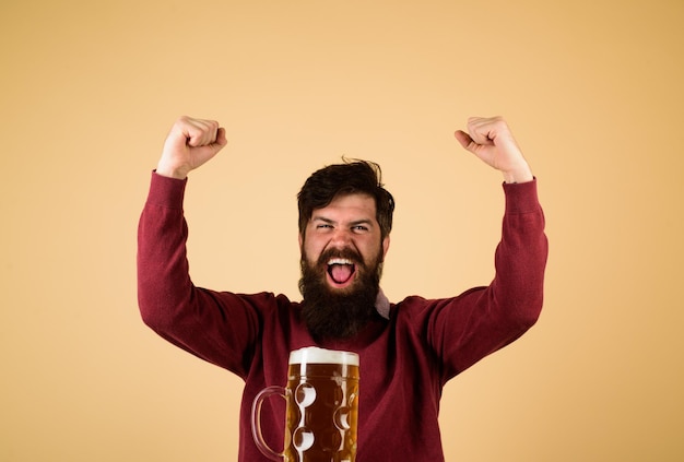 ビールの準備のためのドラフトビール機器を試飲するラガービールの男とビールの興奮したひげを生やした男