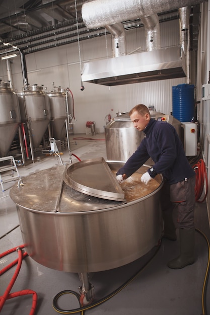 Brewer looking into beer tank during fermentation process