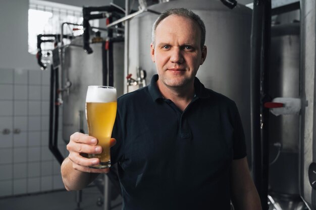 Brewer at a modern brewery with glass of beer