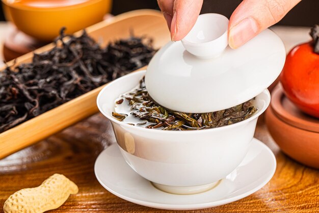 Photo brewing chinese tea in ceramic gaiwan during the tea ceremony closeup