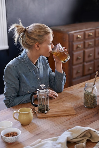 ハーブティーを淹れる若い女性がハーブティーを飲む