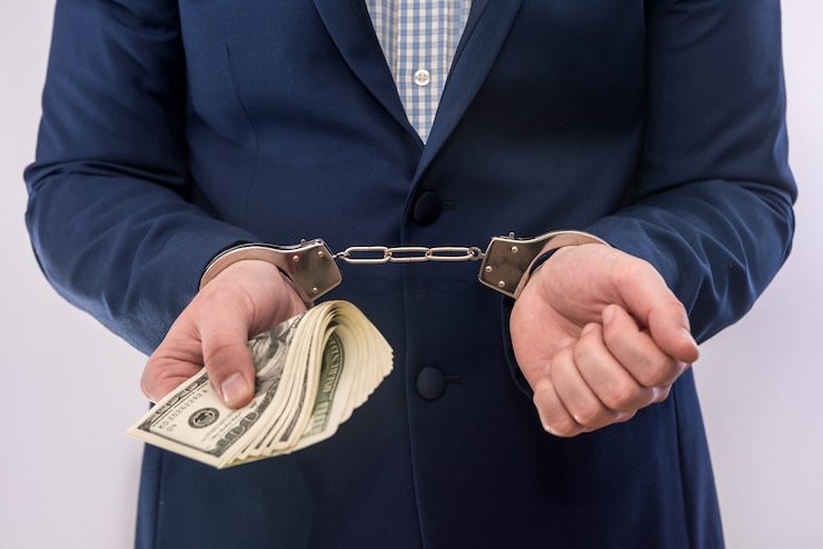 Photo bribe or corruption concept male hands hold dollar bills in handcuff. criminal