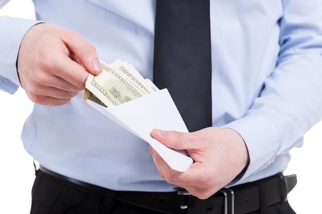 Bribe. Cropped image of man in shirt and tie taking money from the envelope while standing isolated on white