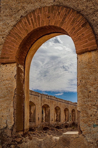 A brick archway with a blue sky in the background