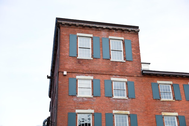 A brick building with blue shutters and a white window