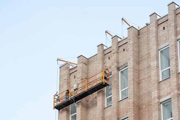 Foto un edificio di mattoni con un uomo in cima