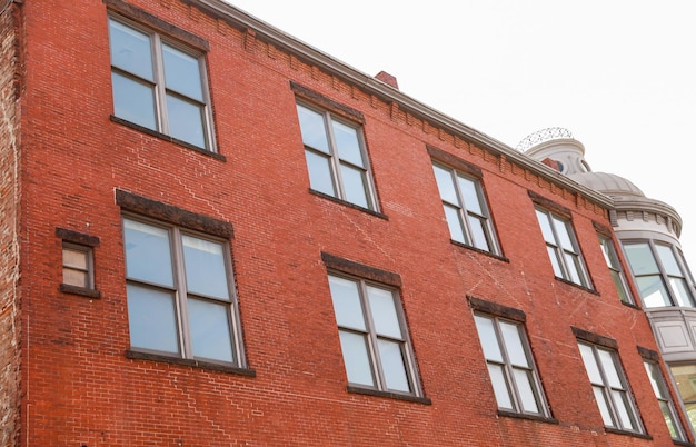 A brick building with a red brick wall and windows