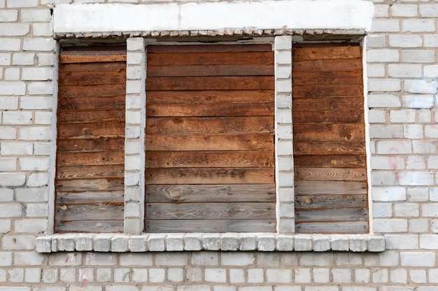 Brick building with wooden windows The windows are filled with wood