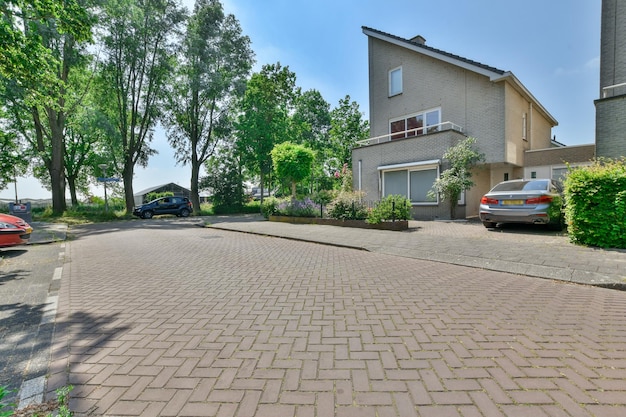 A brick driveway with a house and cars on it