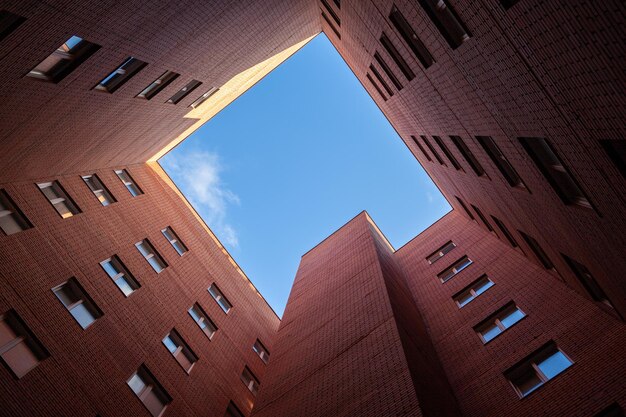 Brick high-rise new square house on a blue sky background. View from the courtyard to the top