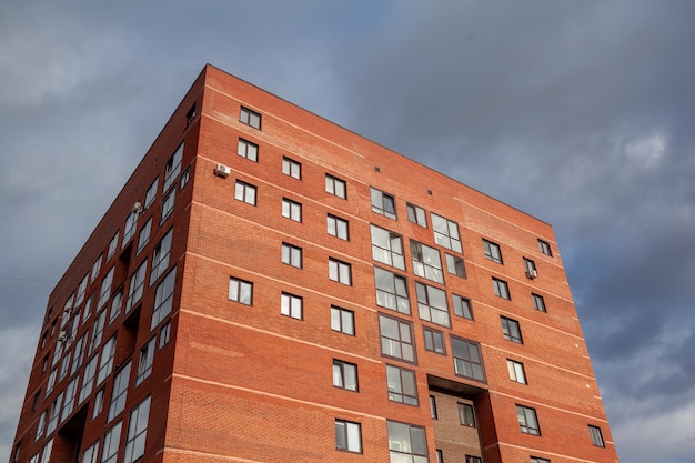 Brick high-rise new square house on a blue sky background. View from the courtyard to the top