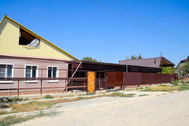 Brick house with a fence and gates View of a new builtup fence and a house made of bricks and corrugated metal