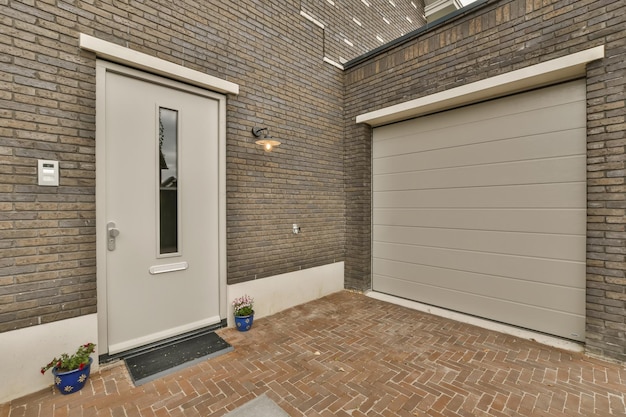 Photo a brick house with two garage doors and one door open to the other side in front of the house