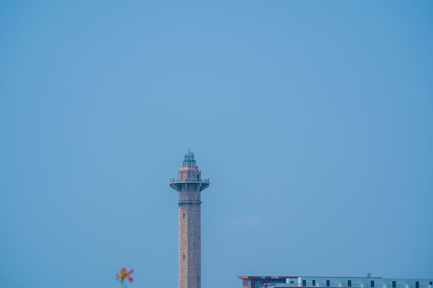 れんが造りの灯台は、非常にかすんでいる日にベトナムのハロン市のバイ チャイ ビーチに位置しています バイ チャイ ビーチは、ベトナムのハロン湾の主要都市のビーチです