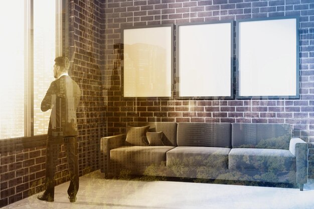茶色のソファとその上にポスター ギャラリーがあるレンガ造りの部屋。ミニマリズムのコンセプト。ビジネスマン。 3Dレンダリングモックアップトーン画像二重露光