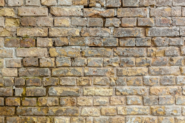 Brick wall Brick wall with bricks of different size and shape of sand color with addition