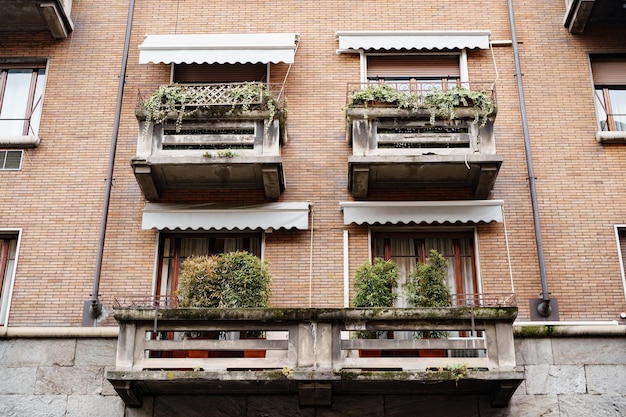 Muro di mattoni di un edificio con vasi di fiori sui balconi milano italia