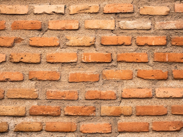 Brick wall made with bricks and with large gaps between their joints filled with cement