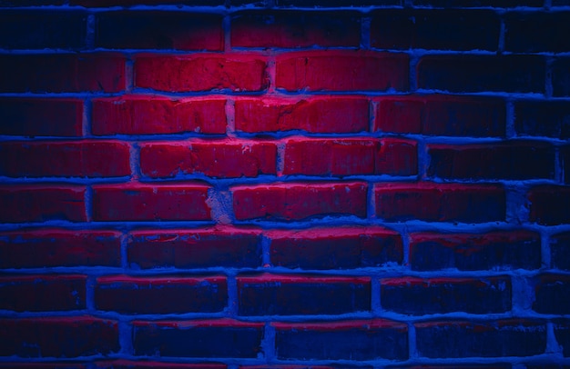 赤と青のネオンライトでレンガの壁のテクスチャの背景