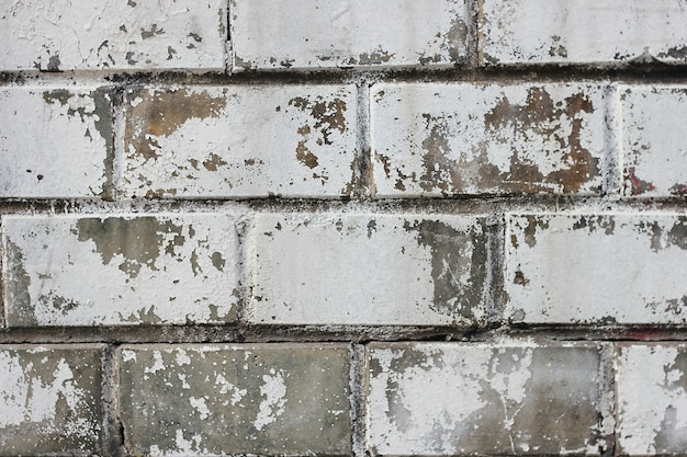 Brick wall with a worn-out pattern and traces of old paint