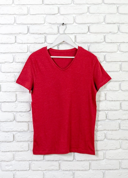 Photo brick whitewashed wall with t shirt on hanger