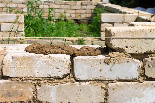 Bricklayer installs brickwork on the outside Technology of cement masonry buildings