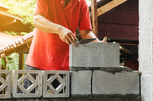 Uomo del muratore che lavora costruire per la costruzione a casa