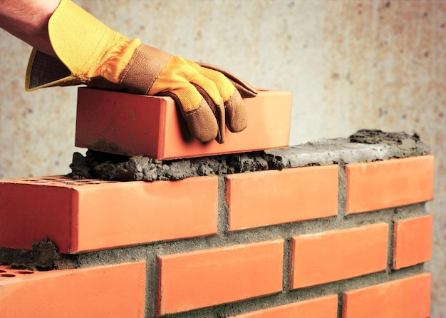 Bricklayer worker installing brick masonry