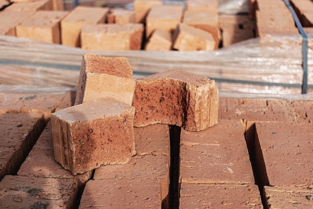 Bricks in pallets on a construction site. Construction Materials. Red brick for building a house.