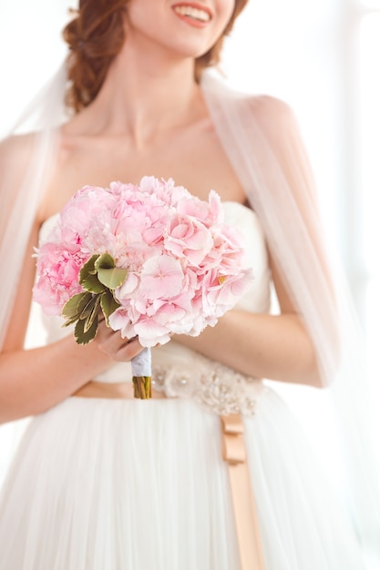 Bridal bouquet Beautiful of pink wedding flowers in hands of the bride