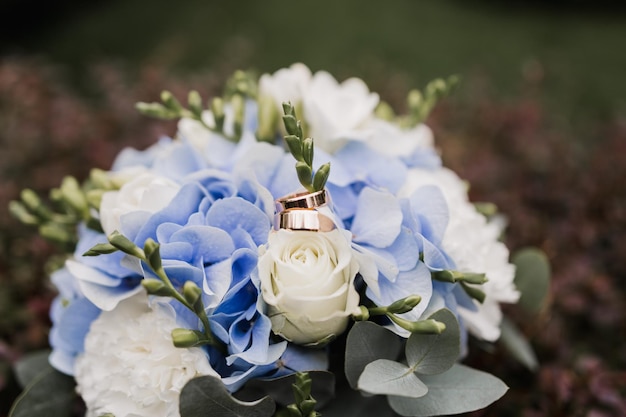 金の結婚指輪と花のブライダルブーケ