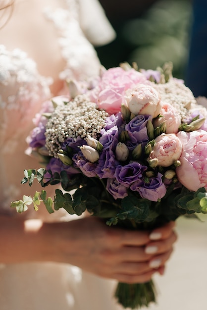 Foto bouquet da sposa nelle mani sposa mattutina in primo piano