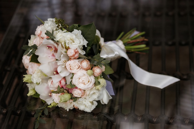 Bridal bouquet on a mirror surface. wedding bouquet with a white ribbon. classic style wedding. florist