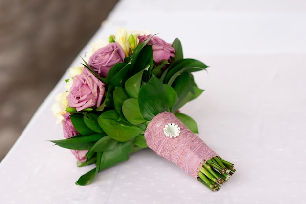 Bridal bouquet of purple and white roses on the table