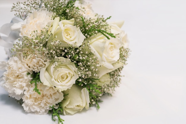 Bridal bouquet of white rose on white fabric background