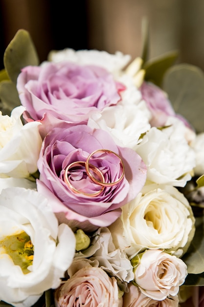 Bouquet da sposa con fiori viola e bianchi e anelli