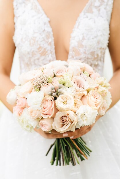 Bridal morning details with beautiful bouquet in the hands of the bride