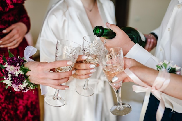 Фото Свадебное утро с подружками невесты пьют шампанское невеста в шелковой пижаме девушки и мужчина на вечеринке с бокалами шампанского подружка невесты с женихом и невестой пьют шампанское перед свадьбой