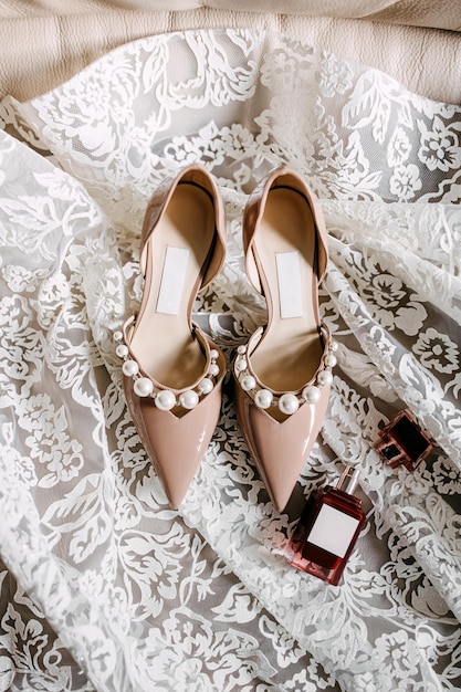 Korean biord talent Premium Photo | Bridal pearl wedding shoes and a bottle of perfume placed  on a lace bridal gown top view