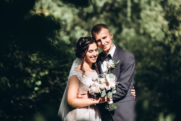 写真 花嫁と花婿の抱擁、結婚式の日に屋外でキス、若いカップル、バレンタインデー