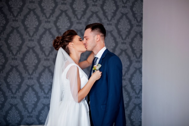 Sposa organizzando un fiore sul vestito dello sposo e lo bacia