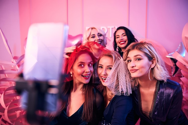 Photo bride-to-be photographing herself and friends using a selfie stick