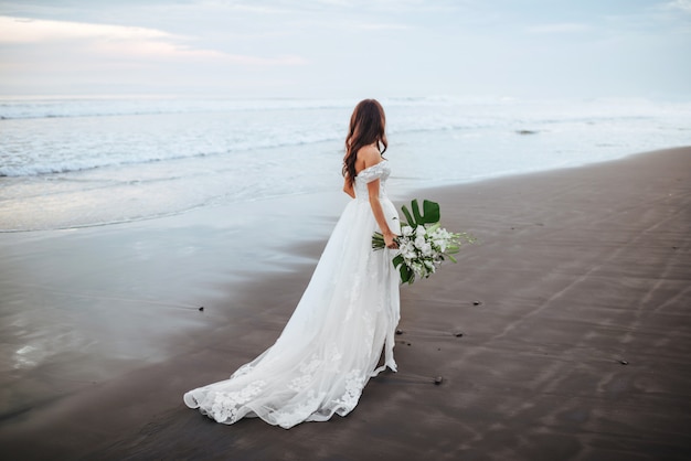 Foto sposa su una spiaggia nell'acqua blu