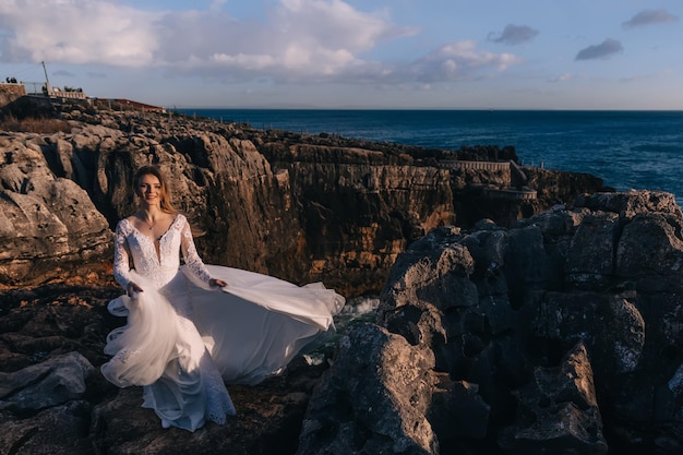 Bride in a beautiful wedding dress admires the view and smiles