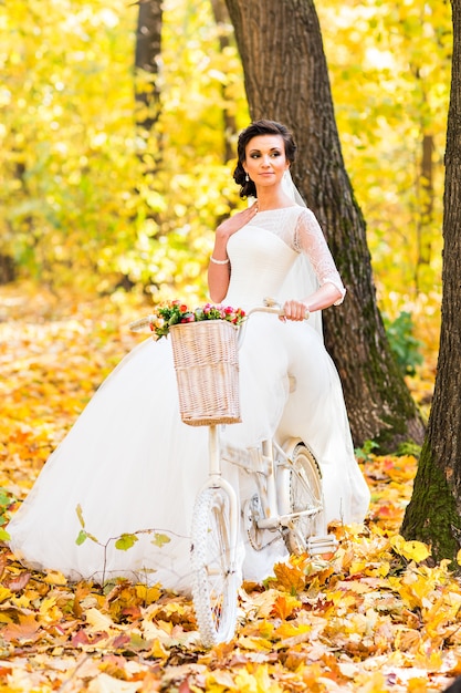 秋の自然の中で自転車に乗る花嫁